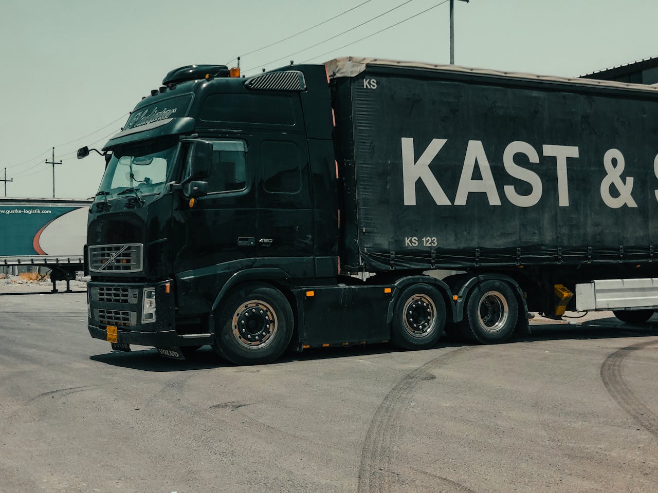 why-choose-us A large industrial truck parked in an urban setting, showcasing transportation industry visuals.